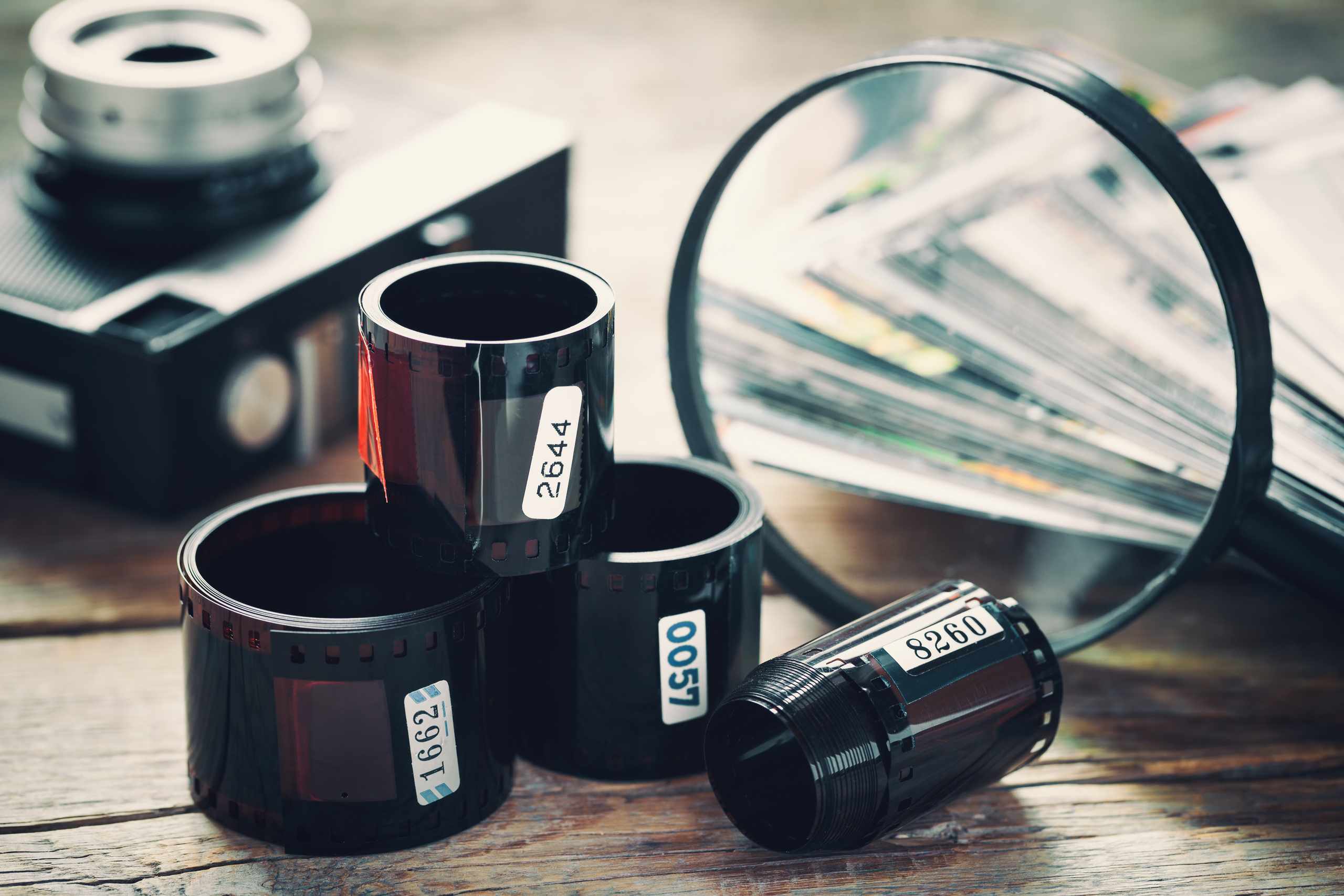 Film rolls and magnifying glass still life